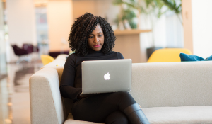 Lady sitting on couch on her laptop