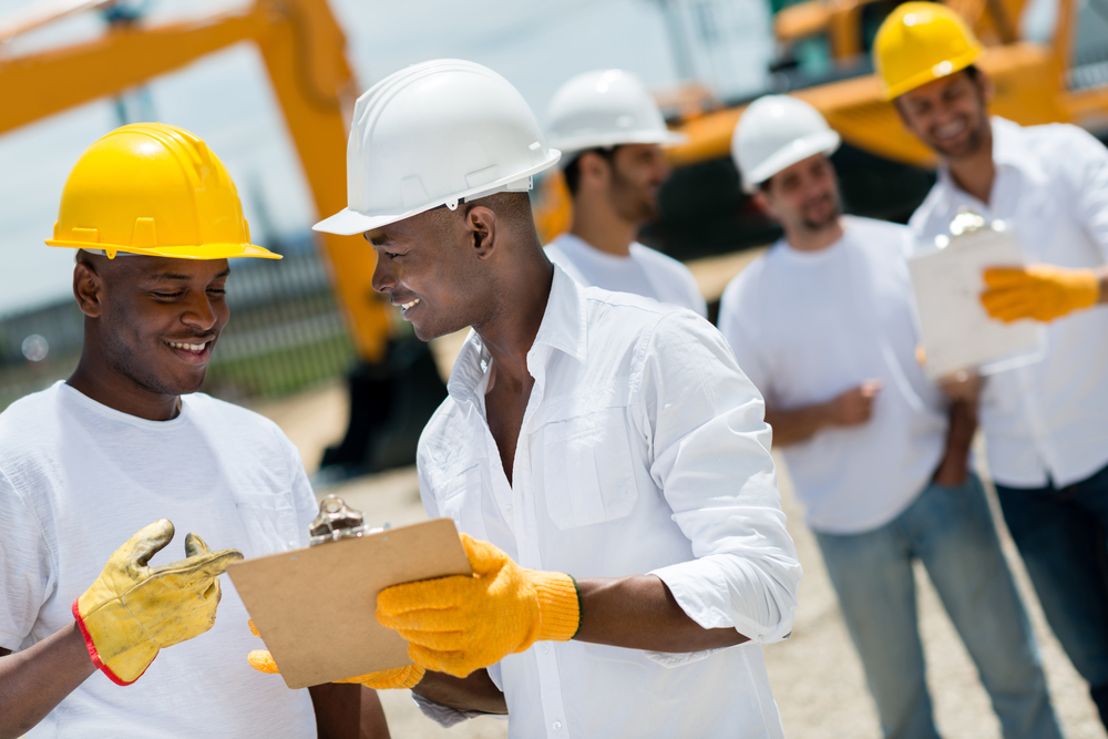Happy architects working at a construction site outdoors Happy architects working at a construction site outdoors